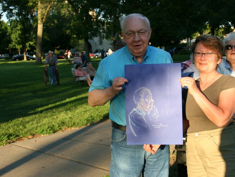 A concert goer poses with a caricature created by Irina Mikhaylova.