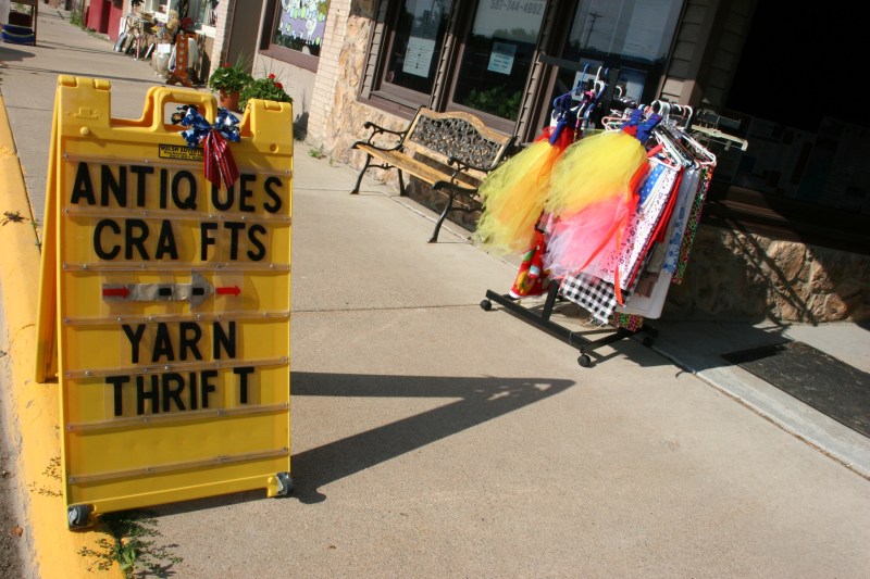 Sidewalk signage directs shoppers to several downtown businesses.
