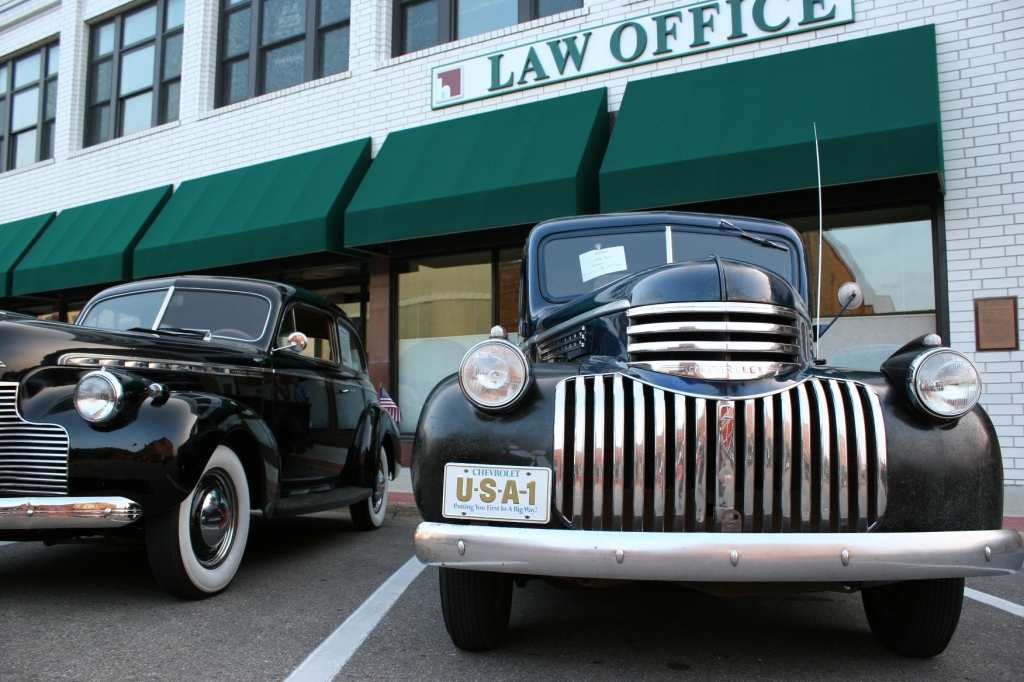 These two vintage cars staged side-by-side with the simple building back drop caught my eye.