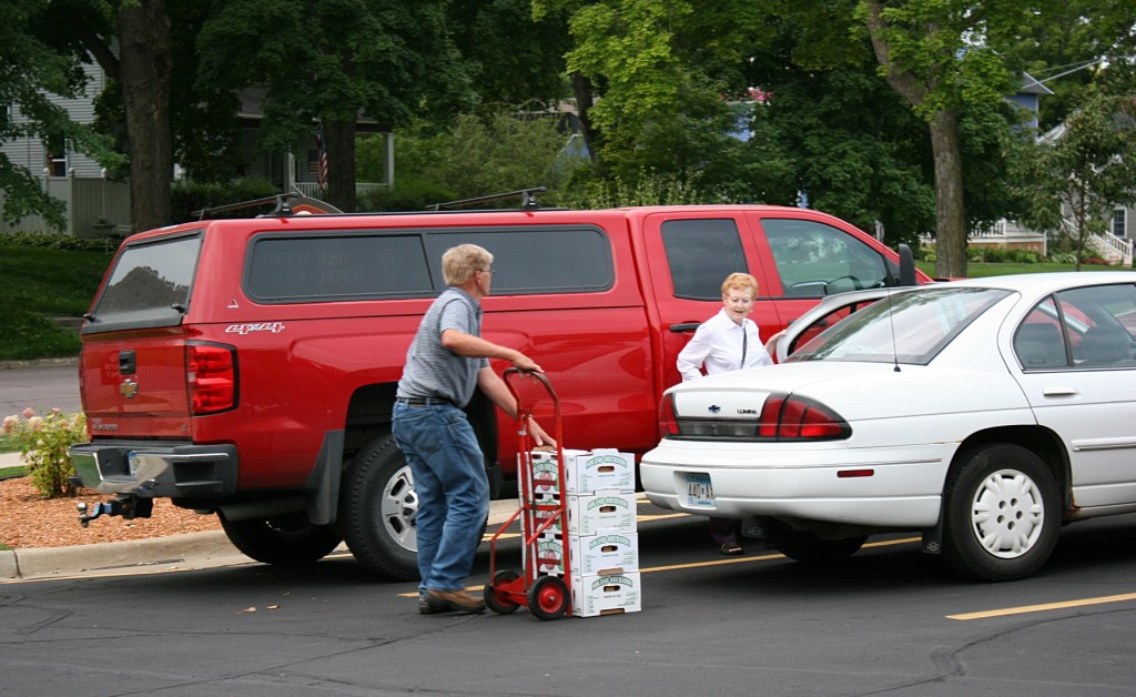 Volunteers are available to wheel peaches outside and load into vehicles.