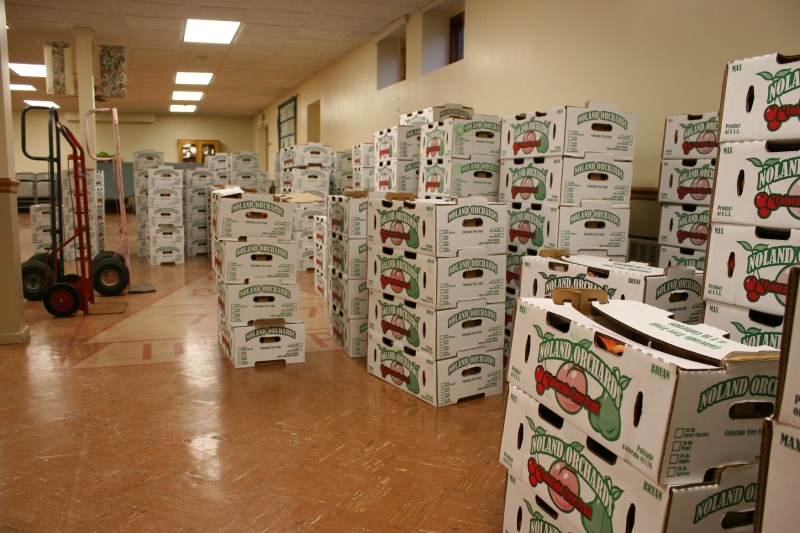 Boxes of peaches await pick-up in the basement of First English Lutheran Church.
