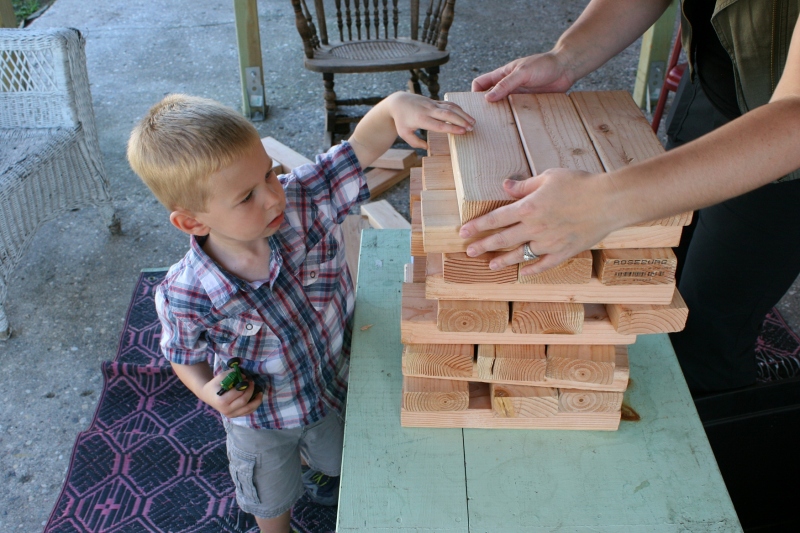 This little guy wouldn't even set down his toy John Deere tractor to stack over-sized Jenga blocks.