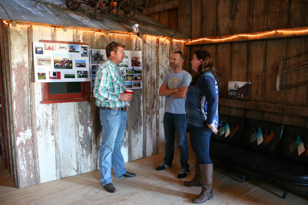 Guests gather in a corner near a display of Becker family farm photos.