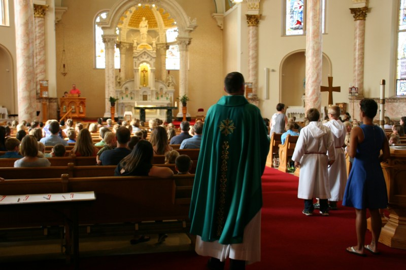 The priest is about to proceed up the aisle to begin Mass.