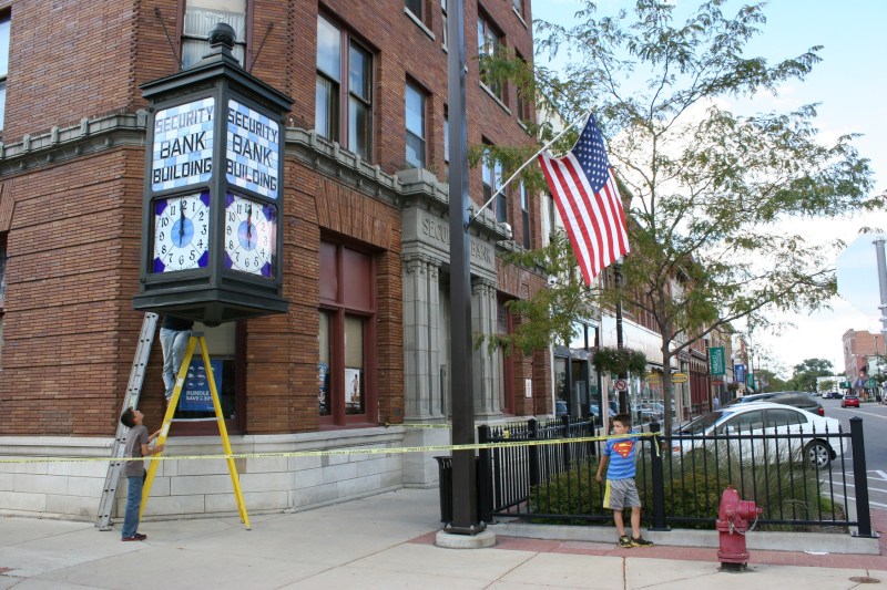 Mike's other son, Tommy, dressed in a Superman shirt, watches.