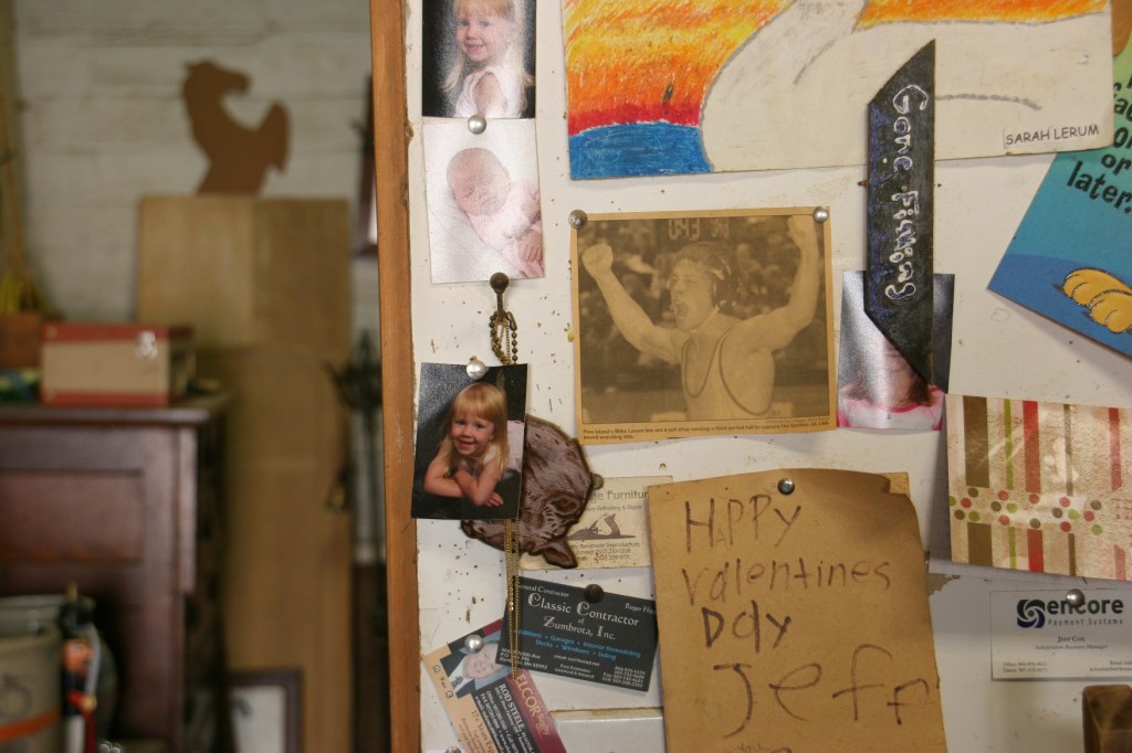 A snippet of family photos and more displayed in Jeff's workroom.