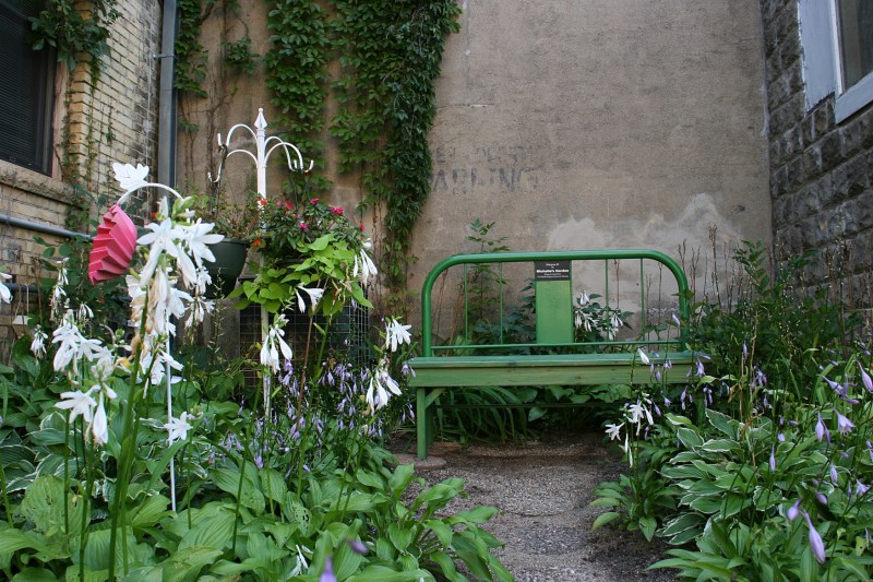 Open the gate and follow the hosta lined path to a bench.