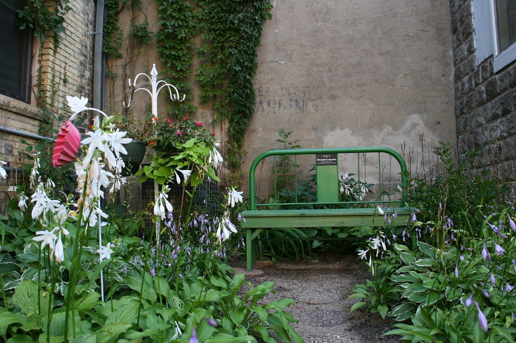 Open the gate and follow the hosta lined path to a bench.