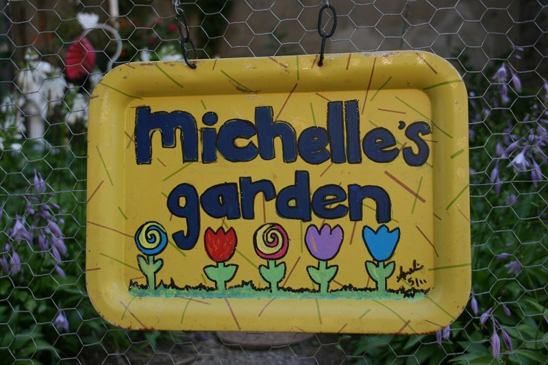 This sign hangs on the garden gate.