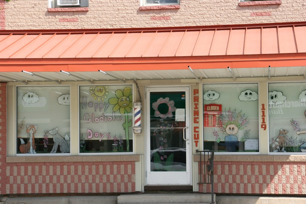 We just missed the Gladiolus Days celebration, promoted in this storefront window. Love the gladiolus "hair."