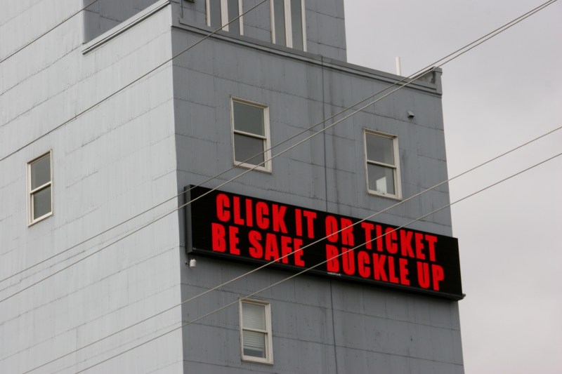 Community service messages and time and temperature flash across the board on an old grain elevator.