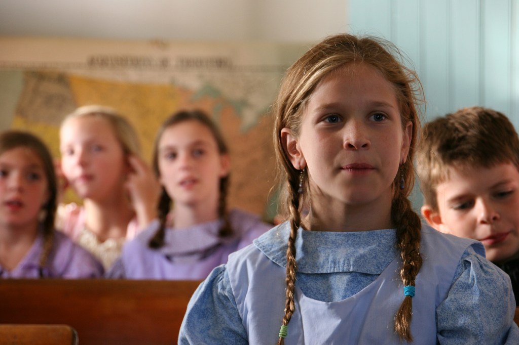 A student reenactor sings along with her class.