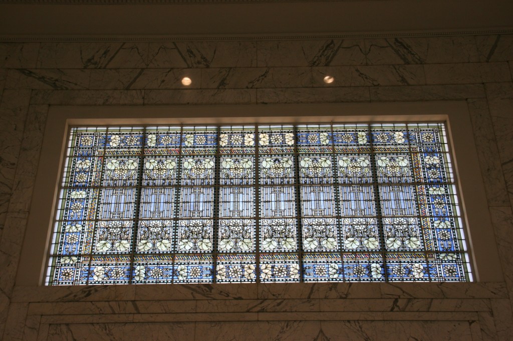 The largest of the Tiffany stained glass windows in the bank looms above the entry. Architect George Maher's Prairie School influences are seen in a design that includes a lotus pattern.