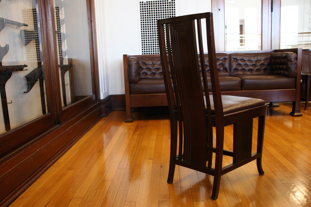 A Prairie School inspired chair in the boardroom, next to the gun collection.