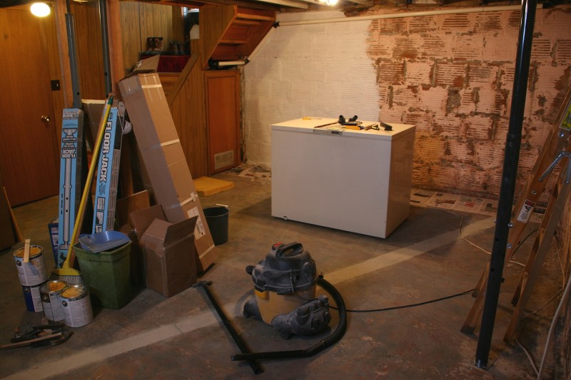 This photo from March shows the basement project in progress. We removed Styrofoam insulation and paneling from the clay tile walls. I then painted walls white. We also removed Styrofoam sheets from the ceiling and I painted the ceiling boards white. Later, we also removed the rest of the paneling from the stairway and surrounding area, replacing it with sheetrock. That, too, was painted white.