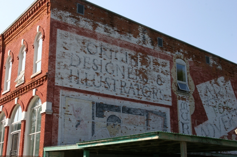 A mural on the east side of the building denotes this as an artist's haven. Cannot you decipher the first word for me?