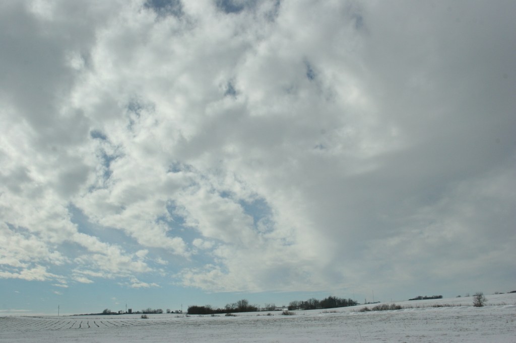 To the west of Interstate 35, clouds billow above snow-washed fields.