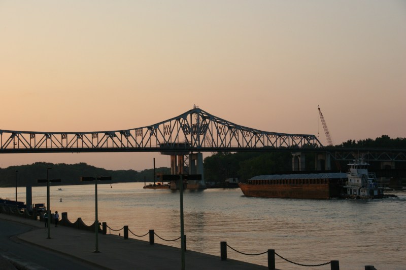 A barge floats near the Mississippi River bridge that connects Minnesota and Wisconsin in Winona.