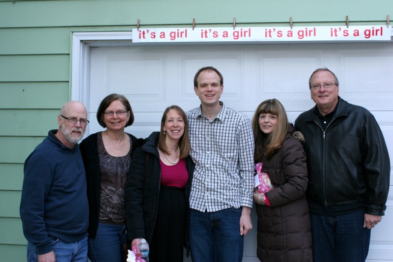 The grandparents-to-be flank the parents-to-be. From left to right, my husband, me, Amber, Marc and Marc's parents, Lynn and Eric. We are standing outside the garage door where I hung the banner. I found the banner packed in a shoebox. Next-door-neighbors hung the banner on our garage door 28 years ago when our youngest daughter, Miranda, was born.