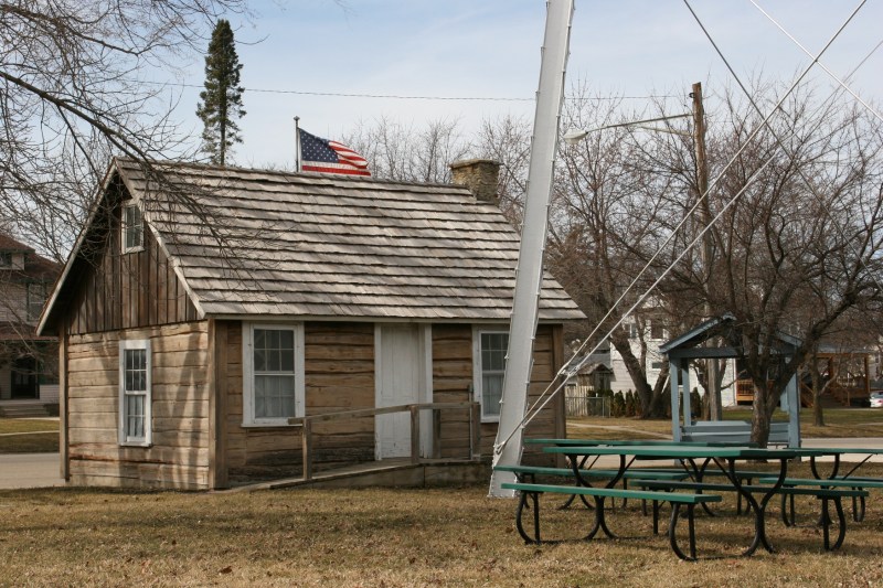 The Lars Larson log cabin sits next to the water tower in Wanamingo. The information center can be seen to the right