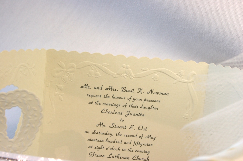 The invitation to the wedding of Charlene Newman and Stuart Ost is displayed in a case.