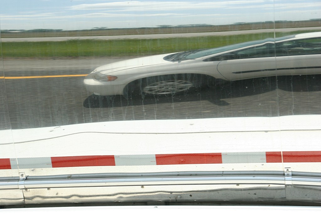 Our van is reflected in the side of a tanker truck while traveling Interstate 80.