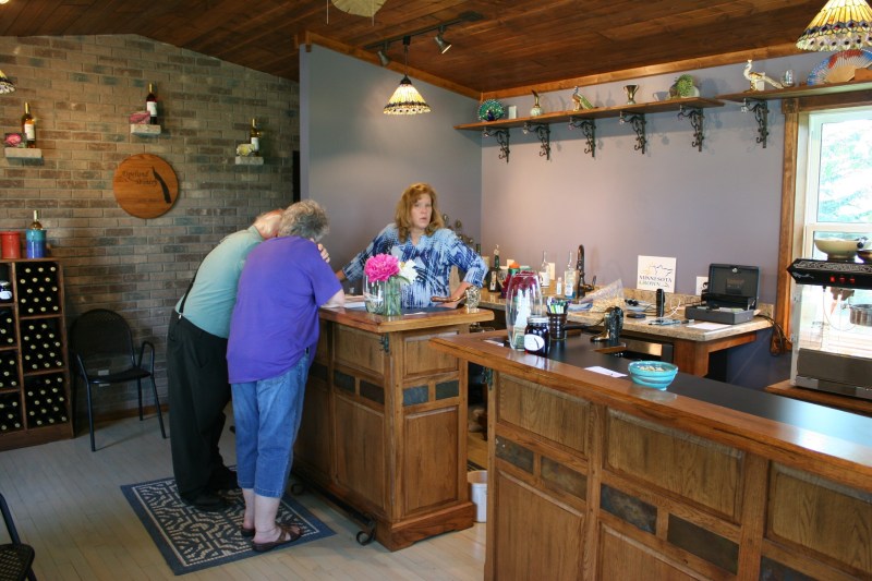 Dawn meets with customers who are perusing a peony catalog in the wine tasting room.