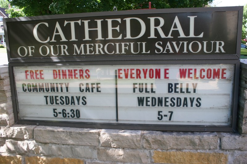 A sign in front of the church advertises the free meals served here twice a week.