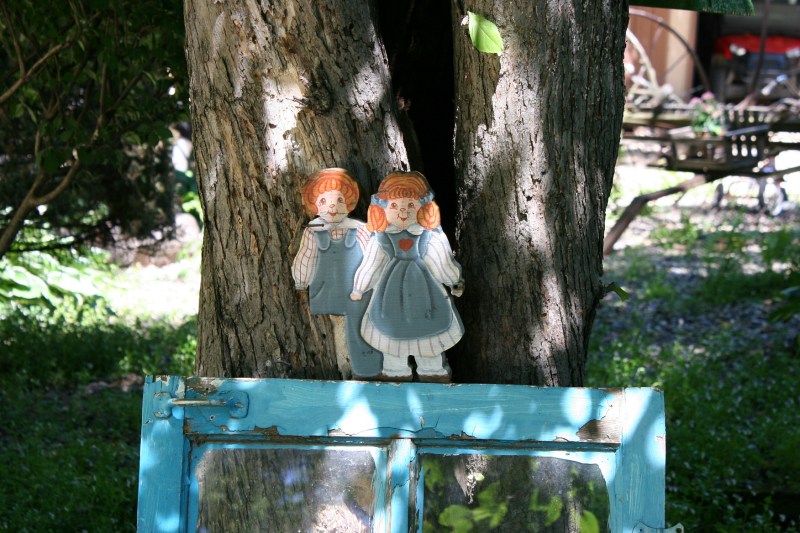 Kitschy art propped against a tree.