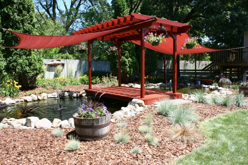Pond, pergola and bridge create a focal point in the yard.