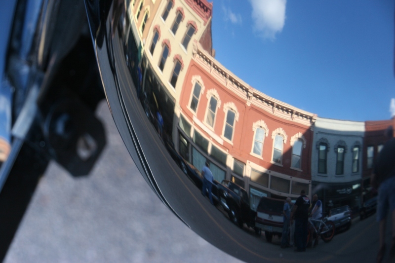 Historic buildings reflected in a polished vehicle at Car Cruise Night.