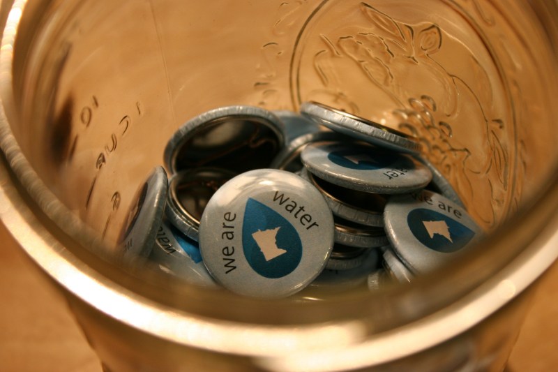"We Are Water MN" pins in a jar at the exhibit.