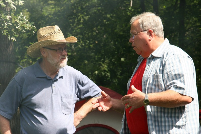 Brothers-in-law Randy and Marty catch up as smoke trails from three grills.