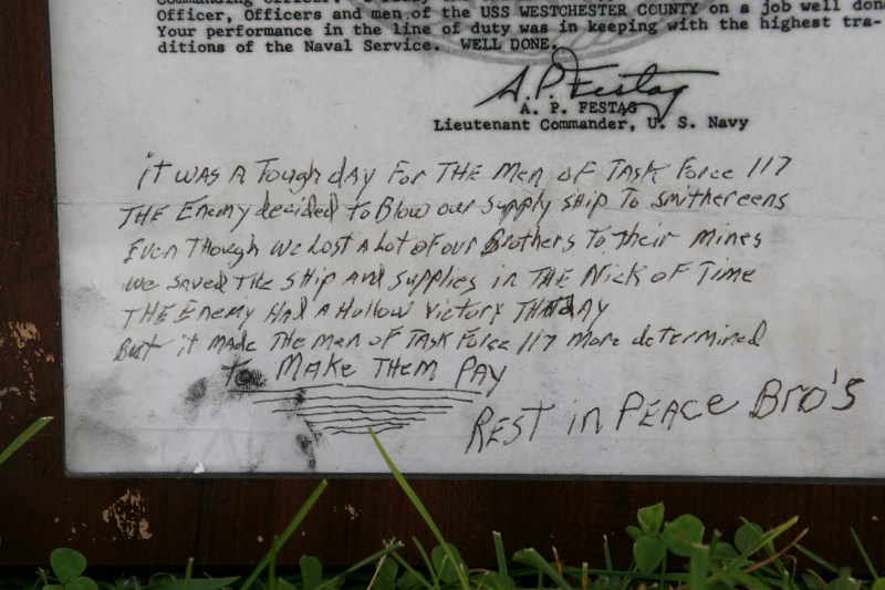A framed letter of commendation with a soldier's notes was left at the wall.