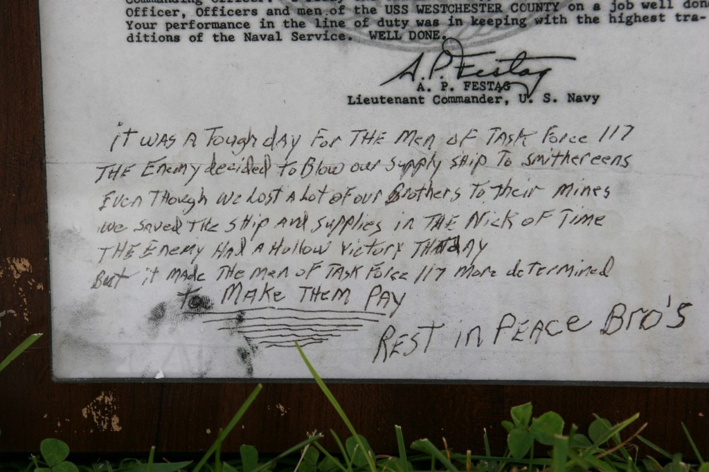 A framed letter of commendation with a soldier's notes was left at the wall.