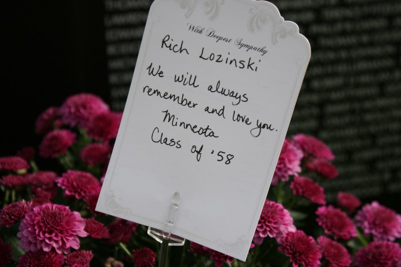 Grief in a note and mums left at the wall in honor of Rich Lozinski, Class of 1958, Minneota, Minnesota.