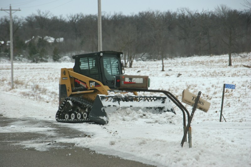 A rural resident cleans out the end of his driveway along Benton County Road 3.