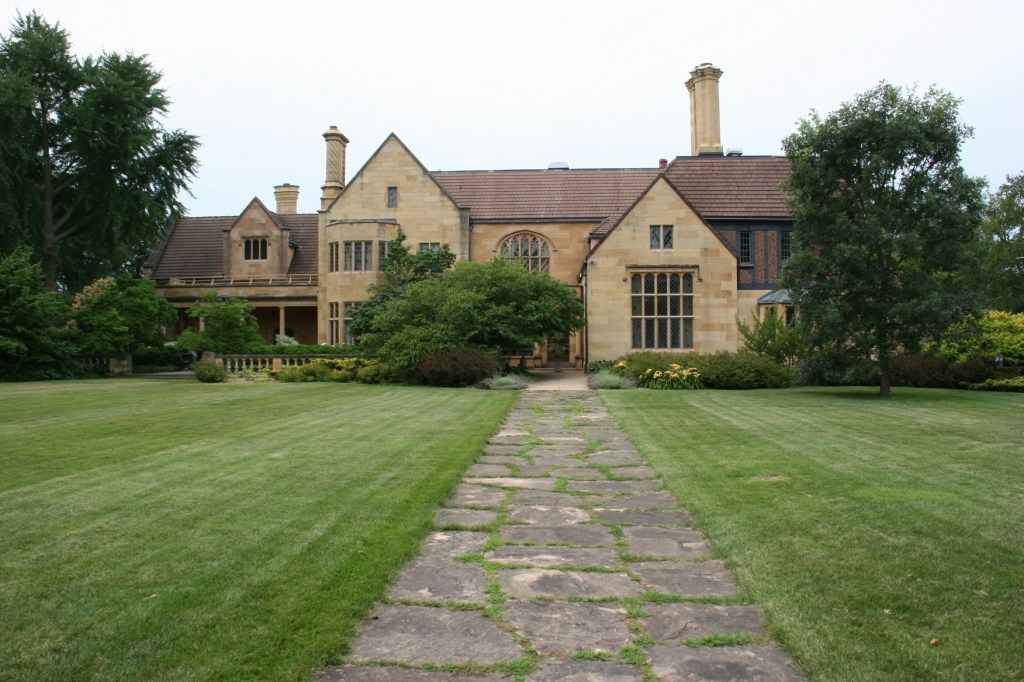 A sweeping lawn stretches between the gardens and the rear of the late 1920s mansion.
