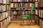Bookstore, #74 green chair among bookshelves